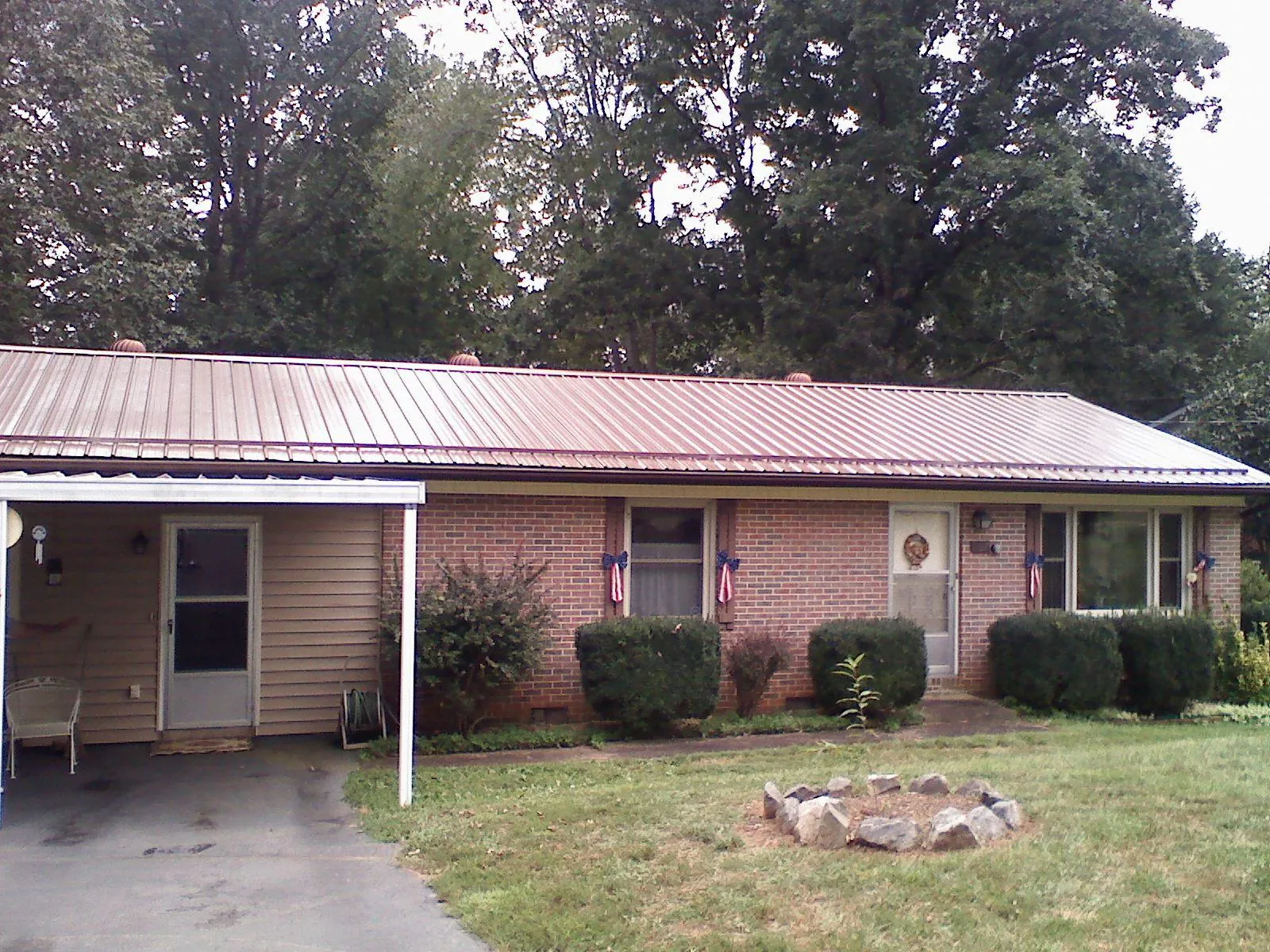 Bronze metal roof and carport on a brick ranch home — Roof Repair work by our crew in Littleton